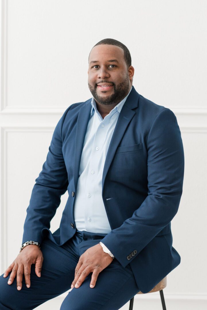 A man in a suit sitting on the ground